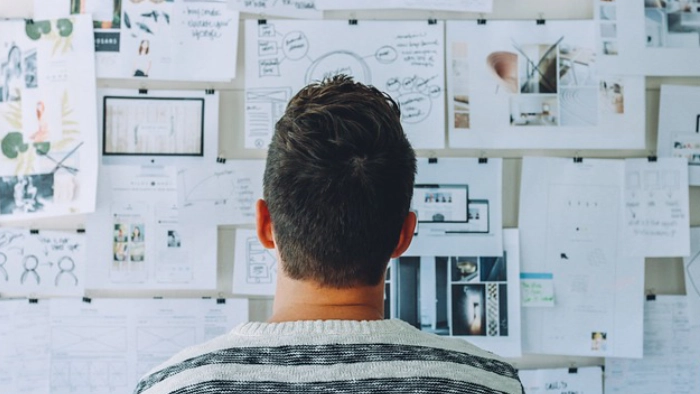 man looking at board with information on it