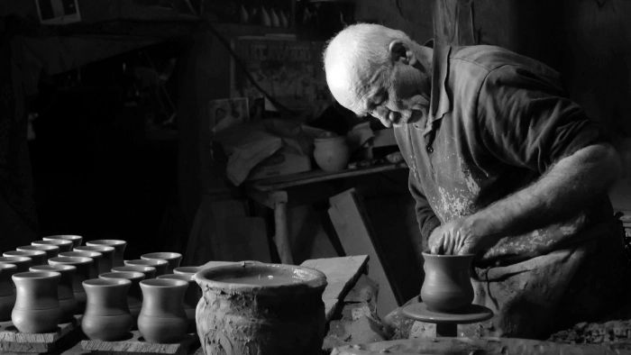 black and white photo of man making ceramic pots